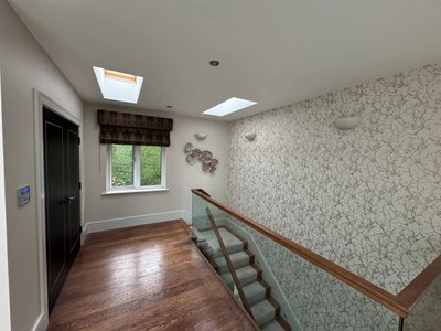 Hallway and staircase with glass panels and patterned wallpaper